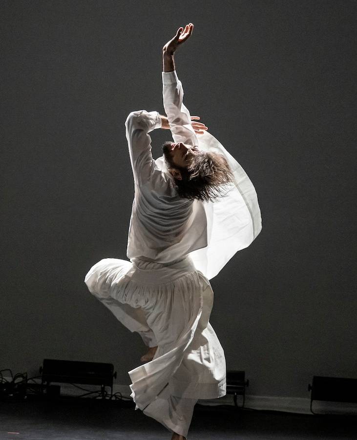 Black and white photo of Pau Aran, mid-movement in a dance studio